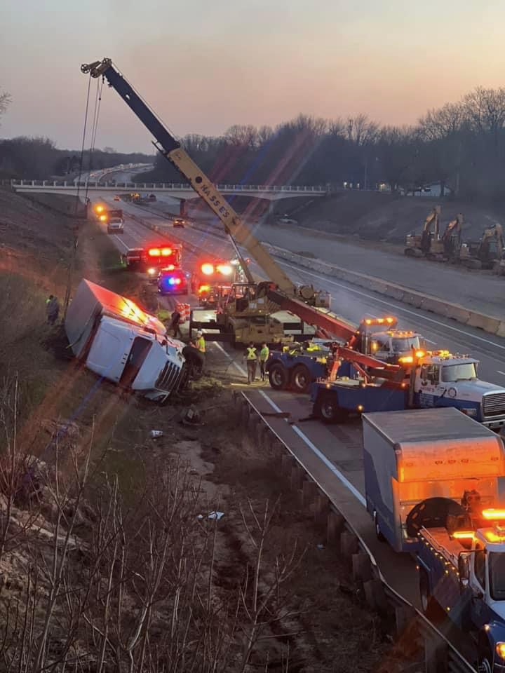 Hasse's crane and fleet recovering an overturned semi on the highway at dusk